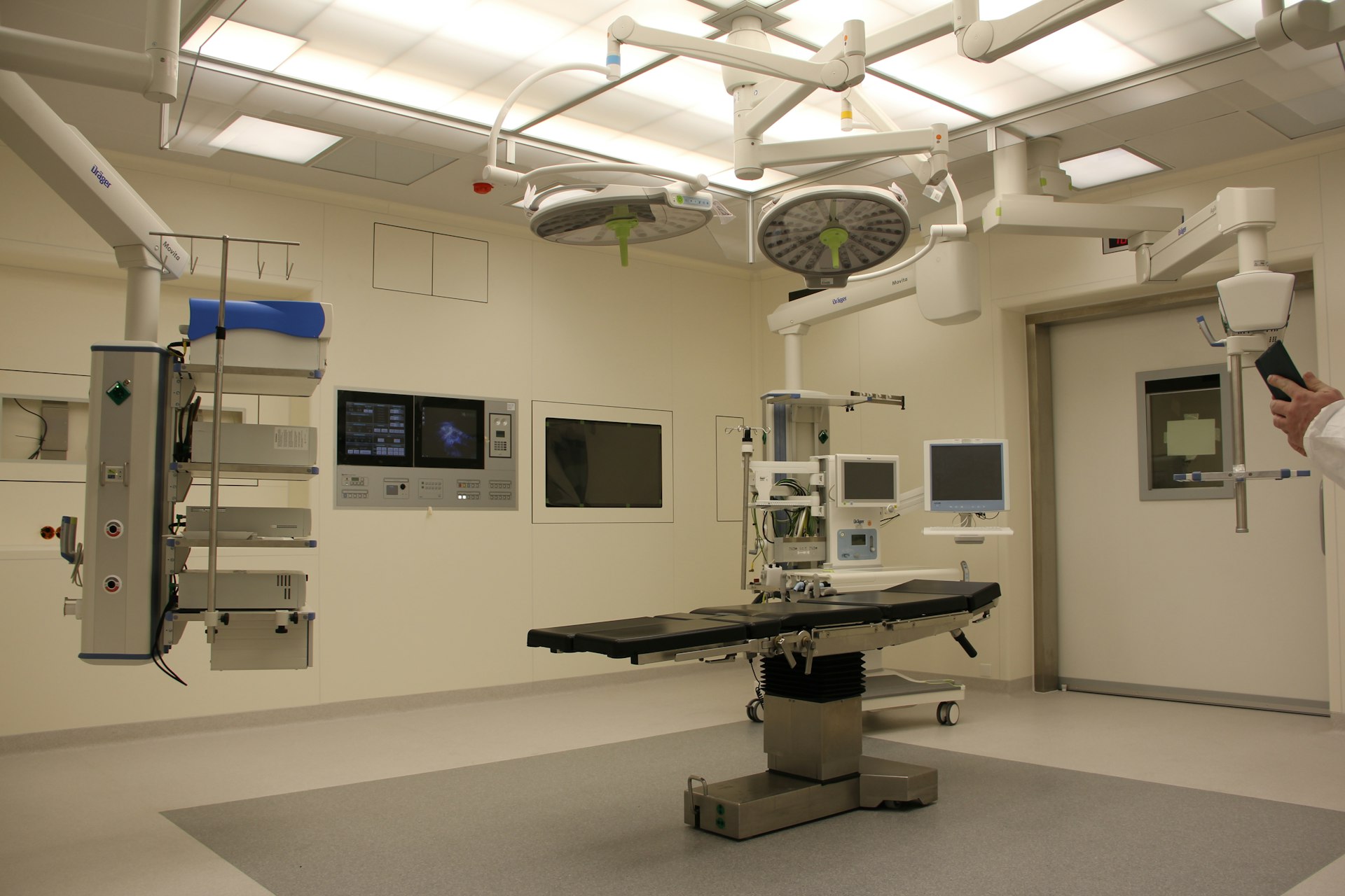 Fully-equipped operating room with dual overhead surgical lights and integrated equipment booms